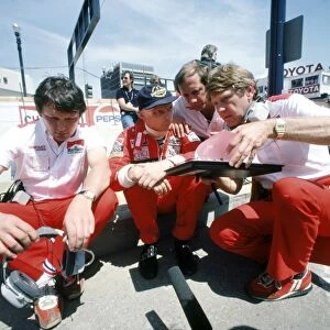 1982 Long Beach Grand Prix: Niki Lauda 1st position, in converstation with Ron Dennis, Tyler Alexander and sitting, John Barnard, portrait