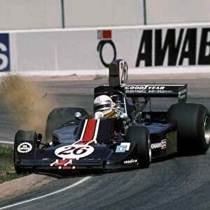 Formula One World Championship: Eleventh placed Alan Jones Custom Made Harry Stiller Racing Hesketh 308B kicks up the dust at the apex of a corner