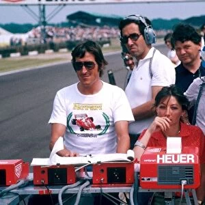 Formula One World Championship: The Ferrari team follow the progress from the pit wall, using the Heuer Centigraph timing mechanism. Joanne Villeneuve