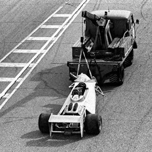 Formula One World Championship: The Surtees TS20 of Vittorio Brambilla is taken away from the scene of the massive start accident which left