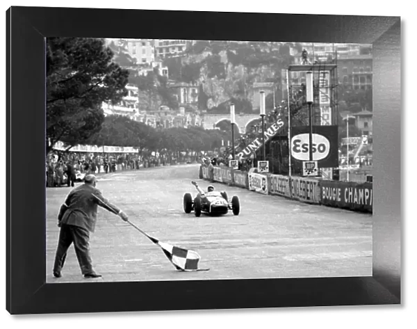 Formula One World Championship: Race winner Stirling Moss Lotus 18 crosses the finish line. This was the first GP victory for Lotus
