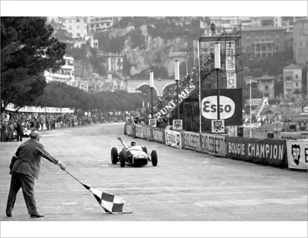 Formula One World Championship: Race winner Stirling Moss Lotus 18 crosses the finish line. This was the first GP victory for Lotus