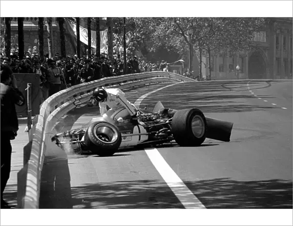 Formula One World Championship: Graham Hill climbs from the wreckage of his Lotus 49B, his rear wing having collapsed on the ninth lap