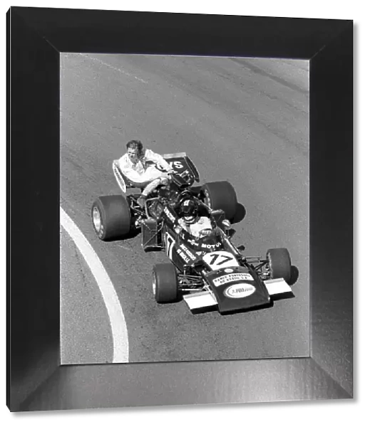 Formula One World Championship: Carlos Pace Frank Williams March 711, gives Ronnie Peterson a lift back to the pits during practice