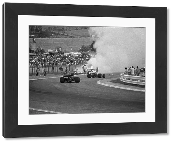 Formula One World Championship: Cars stream past the fiery accident involving Mike Hailwood, Clay Regazzoni and Jacky Ickx on lap 3