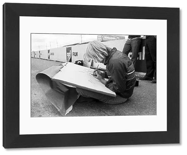 Formula One World Championship: An artist draws the McLaren M23 of race winner Peter Revson in the pits