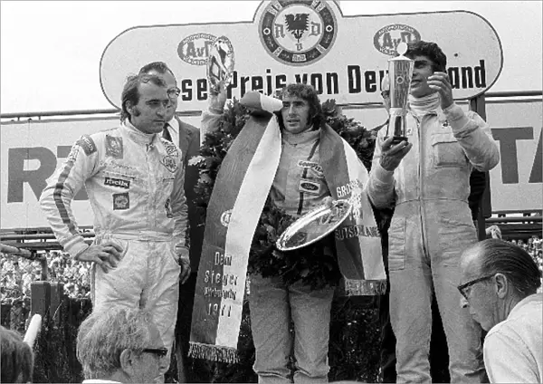 Formula One World Championship: The Tyrrell duo of Francois Cevert right, and winner Jackie Stewart centre, celebrate another 1-2 victory along