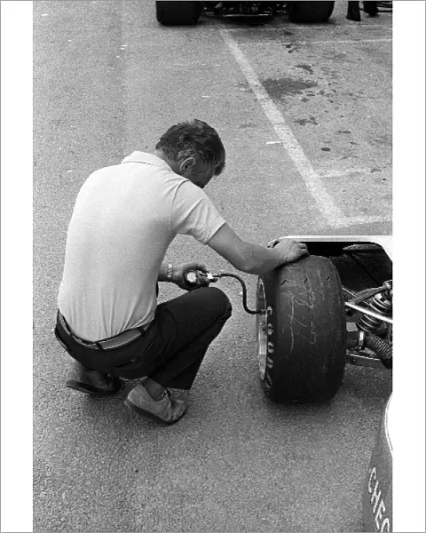 Formula One World Championship: A Penske mechanic checks the tyre pressures of Goodyear tyre on the Penske PC3 of fifth placed John Watson