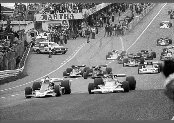 Formula One World Championship: John Watson Penske PC4 pulls ahead of pole sitter and fourth placed finisher James Hunt McLaren M23 at the start of the race