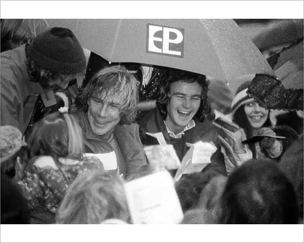 Formula One World Championship: New F1 World Champion James Hunt McLaren and 500cc Motorbike World Champion Barry Sheene are mobbed by fans