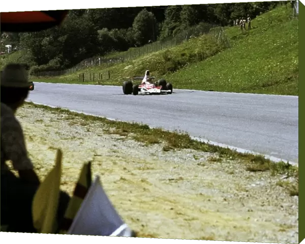 Formula One World Championship: A race marshal watches Emerson Fittipaldi McLaren M23, who retired on lap 38 with a blown engine, storm past him