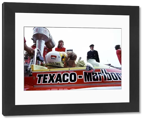 Formula One World Championship: Denny Hulme, who retired on lap 66 with a broken ignition, has his McLaren M23 topped up with Texaco fuel during