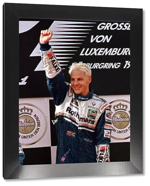 1997 LUXEMBOURG GP. Jacques Villeneuve stands at the top of the podium after winning
