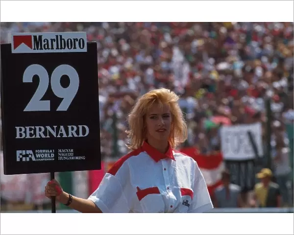 Formula One World Championship: A grid girl holds the board for Eric Bernards Lola