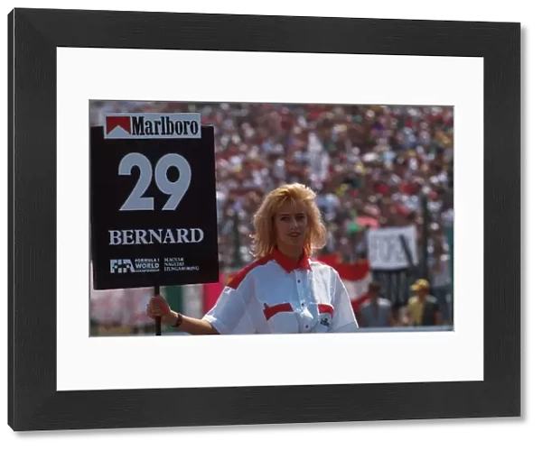 Formula One World Championship: A grid girl holds the board for Eric Bernards Lola