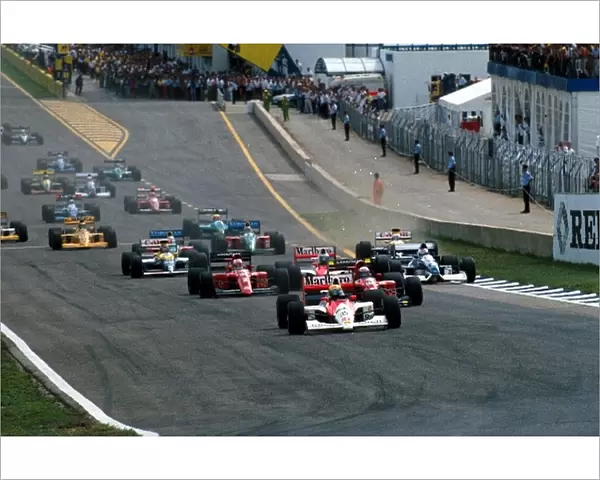 Formula One World Championship: Ayrton Senna leads into the first corner, while Riccardo Patrese gets out of shape on the grass