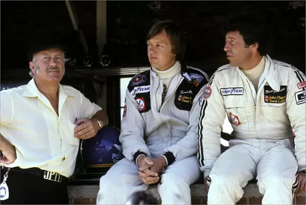 Formula One World Championship: Colin Chapman Team Owner Lotus, chats with his drivers Ronnie Peterson Lotus, centre and Mario Andretti Lotus, right