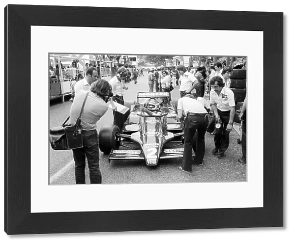 Formula One World Championship: Third placed Carlos Reutemann Lotus 79 in the pits with mechanics and a photographer