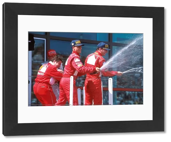 Formula One World Championship: Michael Schumacher Ferrari and Eddie Irvine Ferrari celebrate on the podium