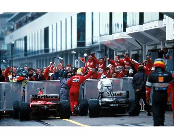 Formula One World Championship: Winner Michael Schumacher Ferrari F1 2000 is greeted by his team members in Parc ferme