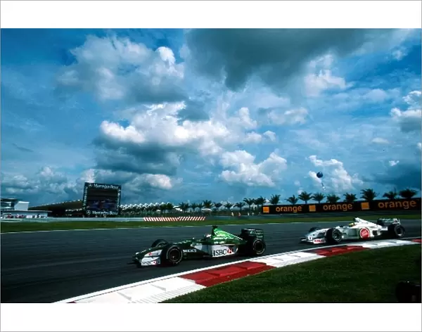 Formula One World Championship: Eddie IrvineJaguar Cosworth R1 leads Ricardo ZontaBAR Honda 002
