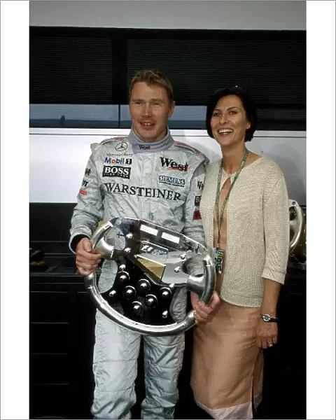Formula One World Championship: Mika Hakkinen Mclaren MP4-15, 1st place. Here with wife Erja