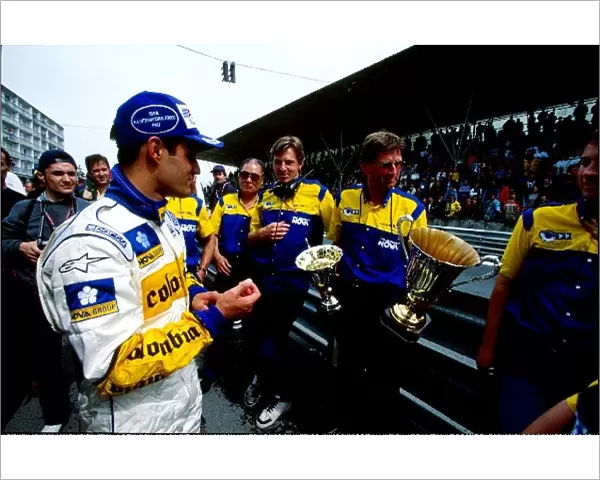 Formula 3000 International Championship: Juan Pablo Montoya examines the trophy with the help of the Super Nova team