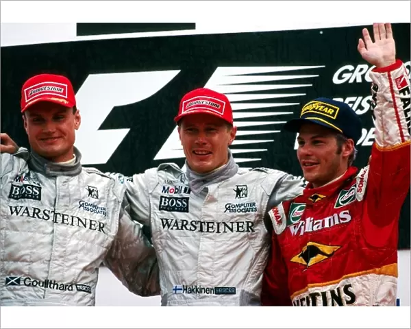 Formula One World Championship: The podium: David Coulthard McLaren, second; Mika Hakkinen McLaren, winner; Jacques Villeneuve Williams, third