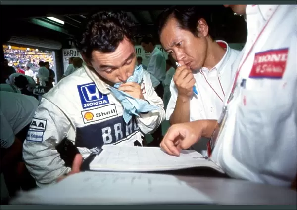Formula One World Championship: Satoru Nakajima Tyrrell confers with his engineers on the occasion of his final Grand Prix