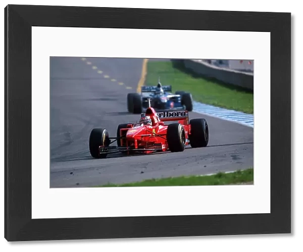 Formula One World Championship: Michael Schumacher Ferrari F310B leads Jacques Villeneuve Williams FW19