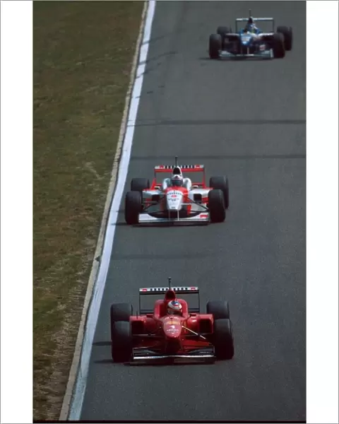 Formula One World Championship: Michael Schumacher Ferrari F310, 4th place leads David Coulthard, 5th