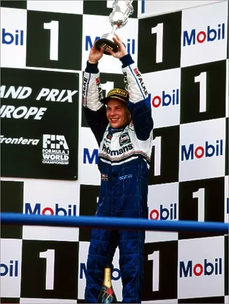 Formula One World Championship: Third placed Jacques Villeneuve Williams celebrates becoming the World Champion on the podium