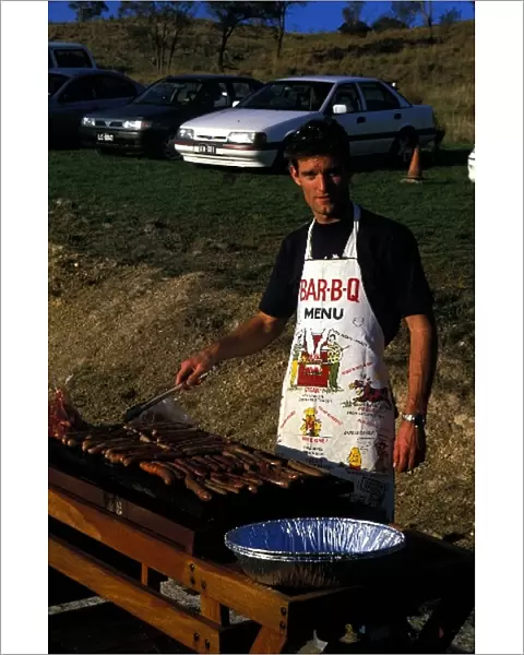 Formula One World Championship: Mark Webber Minardi, tries his hand at cooking sausages on a Barbie'