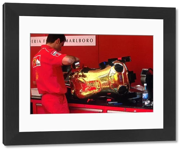 Formula One World Championship: A Ferrari mechanic makes adjustments to one of their drivers seats