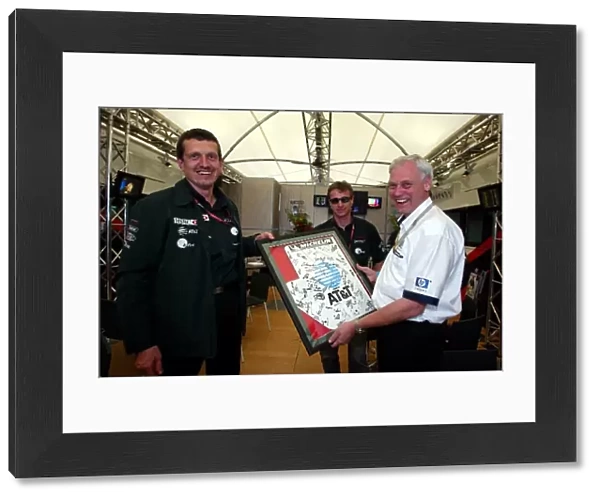 Formula One World Championship: Guenther Steiner Jaguar Technical Director presents a signed print to Rick Parfitt HP