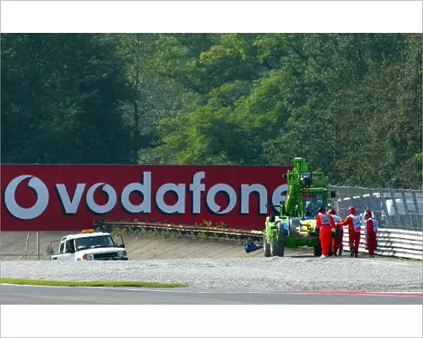 Formula One World Championship: Marshals remove the Renault R202 of Jenson Button from the gravel trap at Parabolica