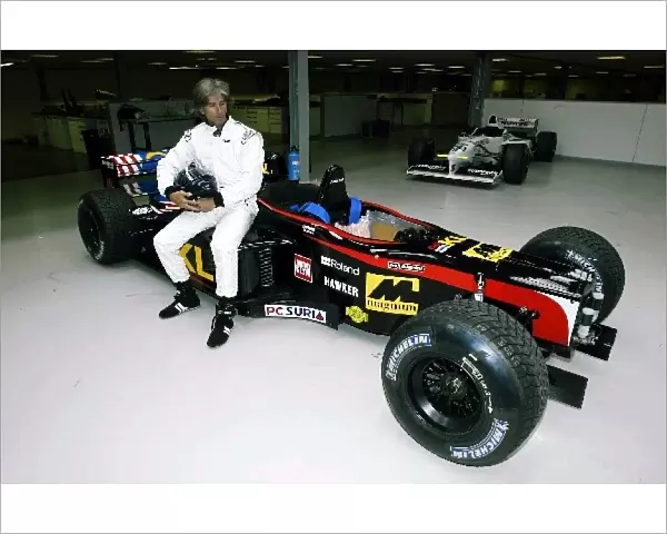 Damon Hill Minardi Seat Fitting: 1996 Formula One World Champion Damon Hill poses with the Minardi two seater Formula One car that he wil drive