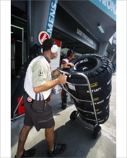 Formula One World Championship: A BAR mechanic picks up tyres with their warmers fitted