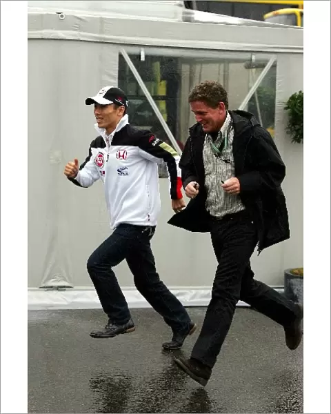 Formula One World Championship: Takuma Sato BAR runs through the rain with his manager Andrew Gilbert-Scott