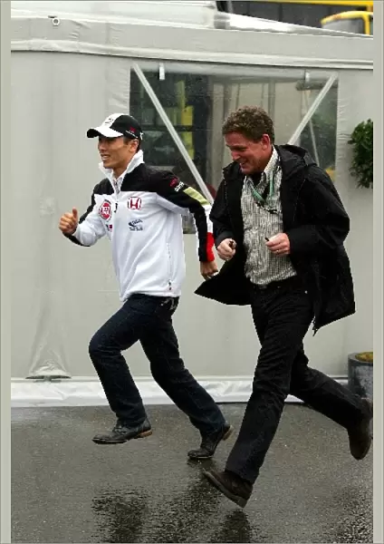 Formula One World Championship: Takuma Sato BAR runs through the rain with his manager Andrew Gilbert-Scott