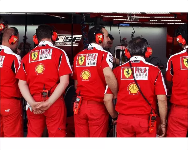 Formula One World Championship: Ferrari mechanics shield the Ferrari F10
