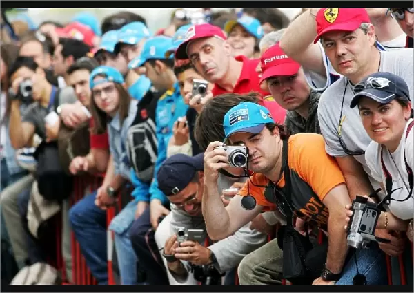 Formula One World Championship: The spectators take advantage of the pit lane being open to photograph their heroes