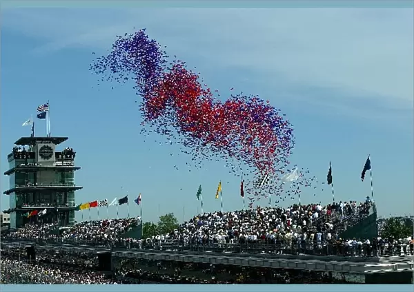 A mass of balloons is released prior to the start of the 86th Indy 500