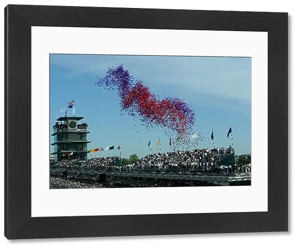 A mass of balloons is released prior to the start of the 86th Indy 500