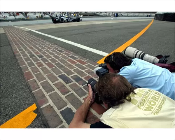 Formula One World Championship: Photographers try and take pictures of the cars on the yard of bricks