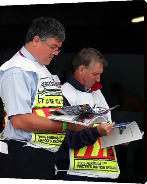 Formula One World Championship: Marshals read the race programme