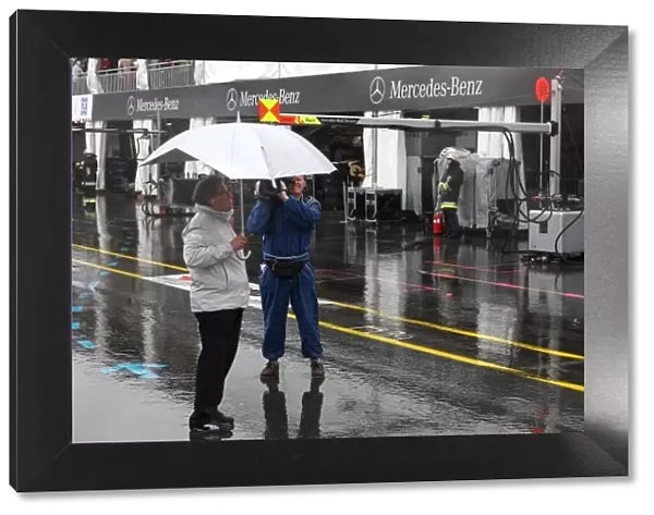 DTM. Norbert Haug (GER), Mercedes-Benz Motorsport Director, shelters from the rain.