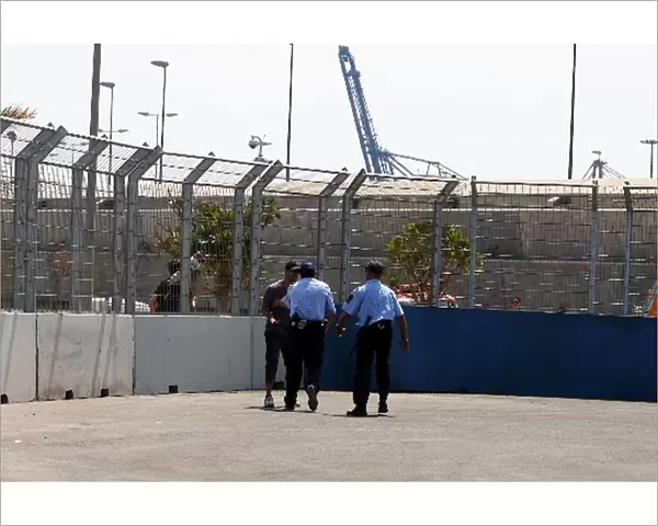 Formula One World Championship: Policemen try to convince a fan off the circuit at the start of the session