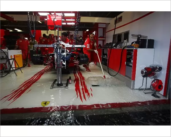 Formula One World Championship: The Ferrari pit garage is flooded during a storm in first practice