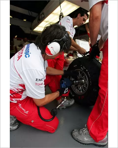Formula One World Championship: Toyota mechanic puts a wheel on the Toyota TF108